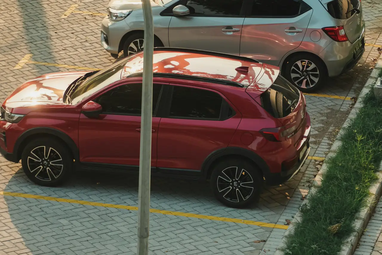 SUV vermelho estacionado numa vaga, visto do alto.