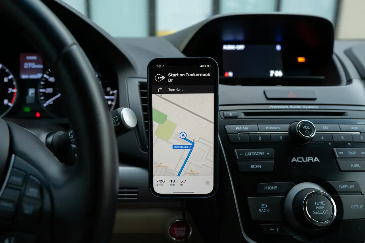 Celular encaixado no painel do carro com um aplicativo de mapa aberto.