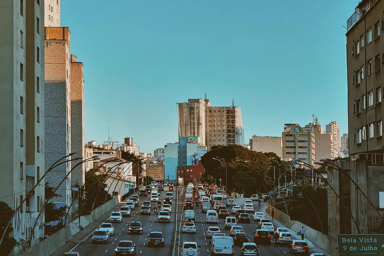 Rua congestionada entre prédios de uma cidade brasileira.