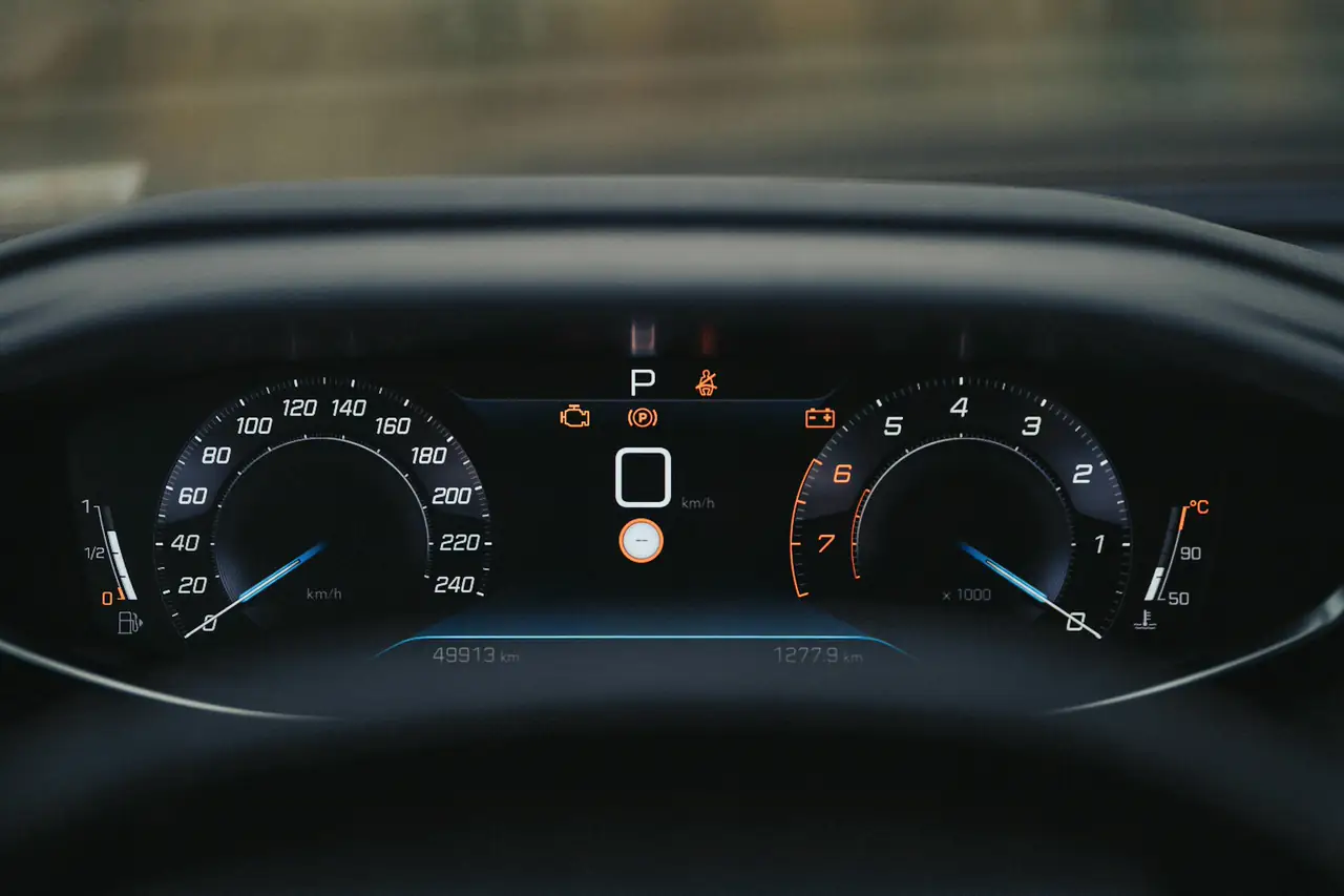 Painel digital de um carro com velocímetro e conta-giros.
