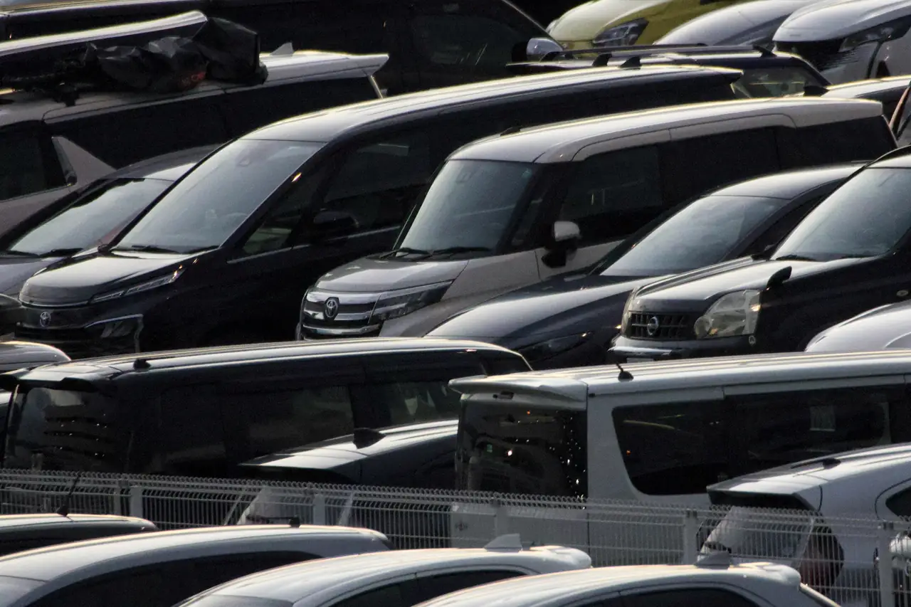 Fileiras de minivans estacionadas lado a lado num pátio.